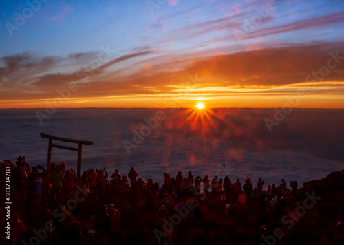 Sunrise (Goraiko) from top of Mount Fuji (Fujisan). People are waiting to see the sun emerge from the cloud.