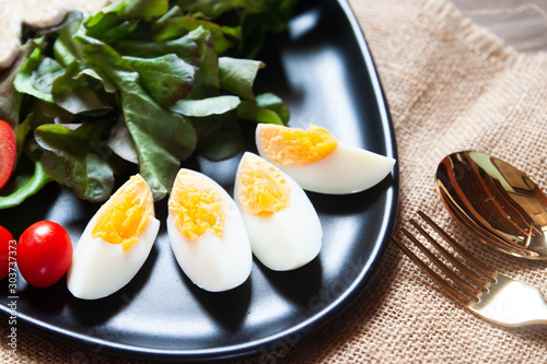 Sliced boiled eggs and vegetables on black plate, Salad dish. Healthy food