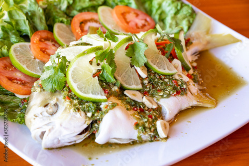 Photos Steam golden pompano fish with chili and lime - spicy thai food
