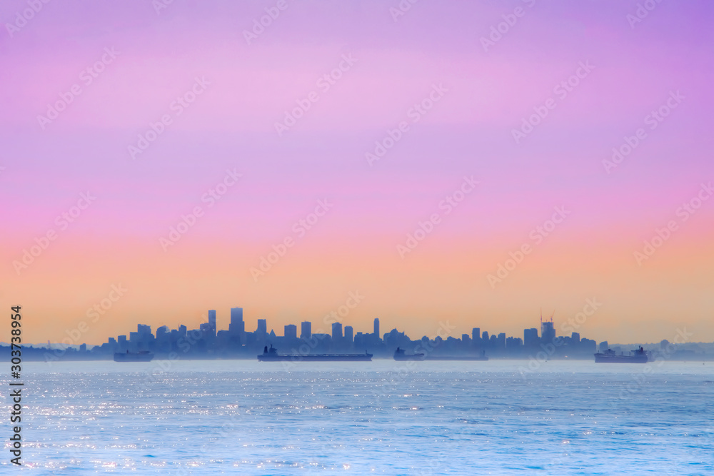 Panorama view of cityscape with colorful sky, ocean and break-bulk carrier 