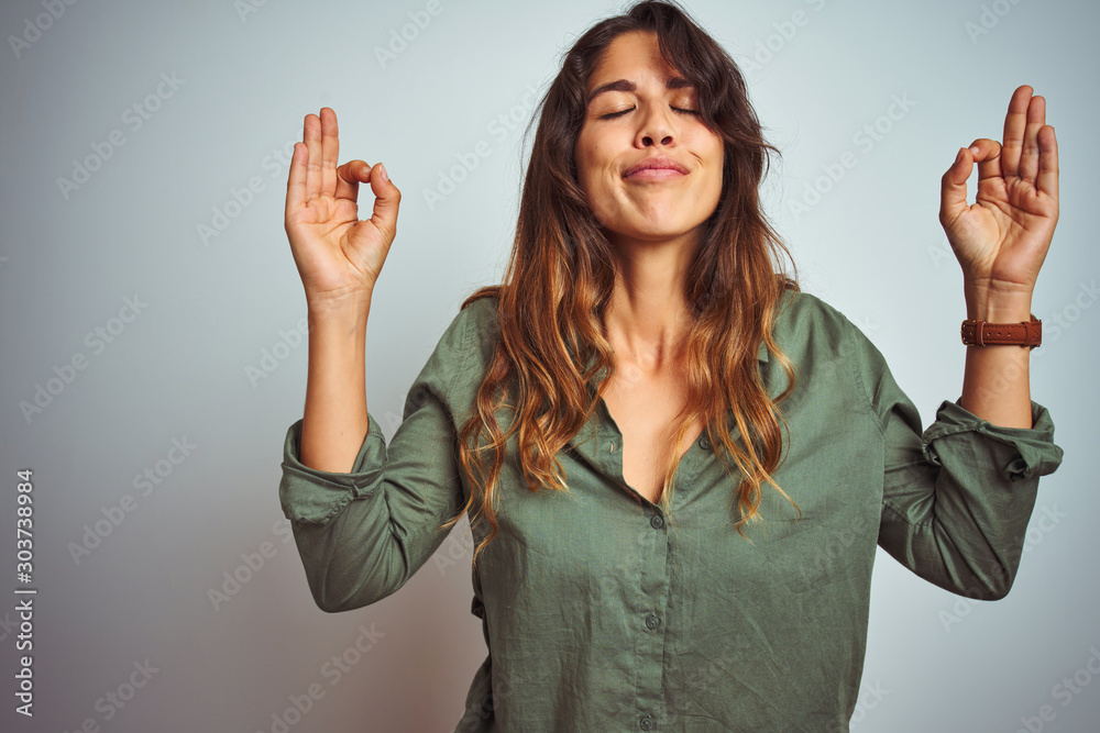 Φωτογραφία Young beautiful woman wearing green shirt standing over grey isolated background relaxed and smiling with eyes closed doing meditation gesture with fingers