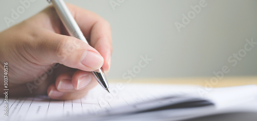 Hand of man signing signature filling in application form document business contract agreement