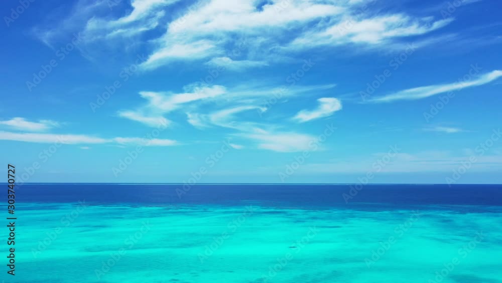 Paradise seascape with bright sky and frozen white clouds shining over deep blue ocean and turquoise lagoon in Bahamas, copy space Paradise seascape with bright sky and frozen white clouds shining over deep blue ocean and turquoise lagoon in Bahamas, copy space