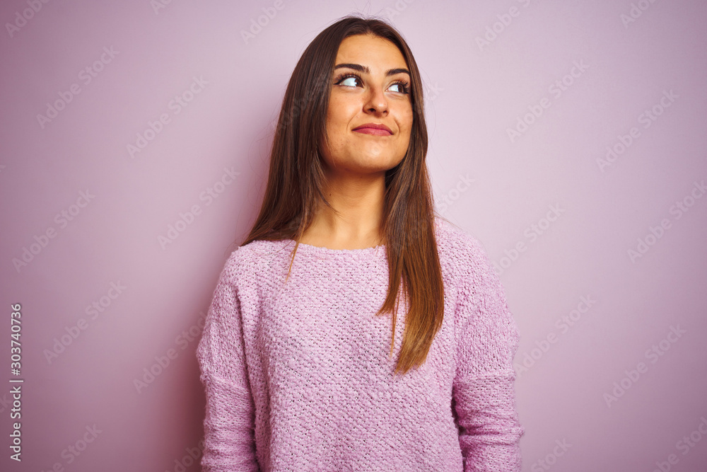 Young beautiful woman wearing casual sweater standing over isolated pink background smiling looking to the side and staring away thinking. Young beautiful woman wearing casual sweater standing over isolated pink background smiling looking to the side and staring away thinking.