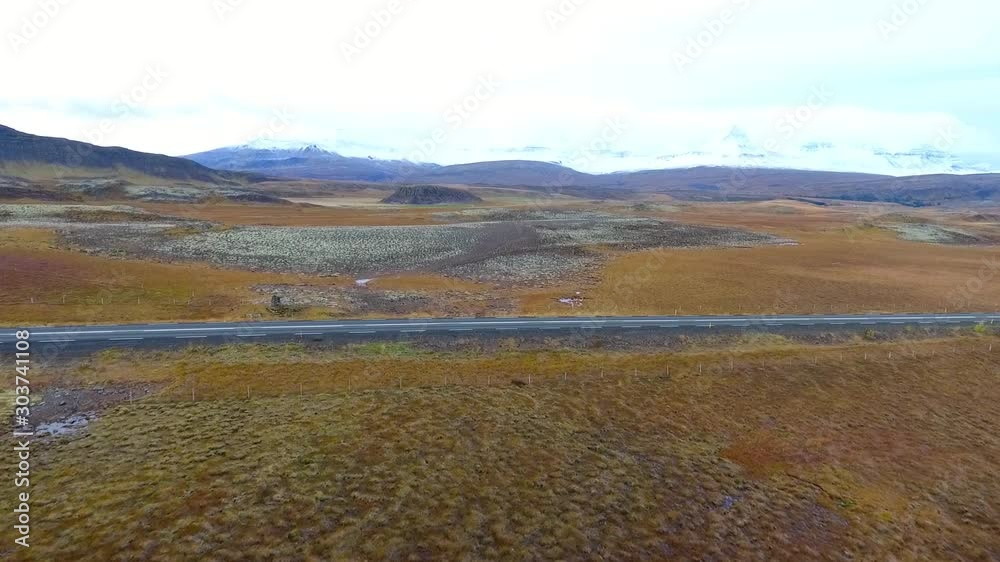 Aerial drone shot flying over a flock of sheep walking on the road in Iceland. Cloudy day, low altitude flight Aerial drone shot flying over a flock of sheep walking on the road in Iceland. Cloudy day, low altitude flight