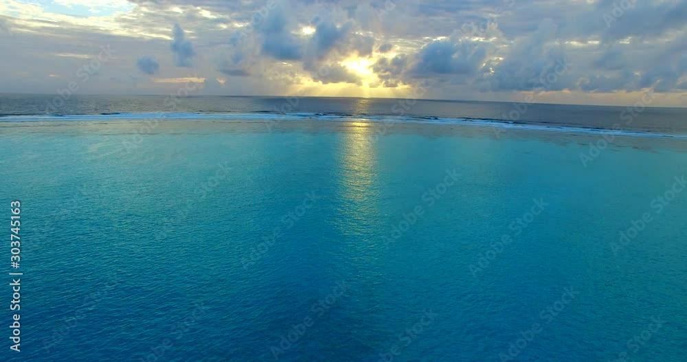 Glowing twilight hidden by dark clouds still reflecting on calm turquoise lagoon surrounded by coral reefs and artificial barriers in Maldives Glowing twilight hidden by dark clouds still reflecting on calm turquoise lagoon surrounded by coral reefs and artificial barriers in Maldives