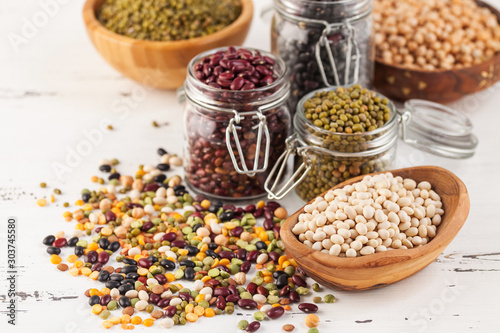 Assortment of dry organic beans and lentils in glass jar photo
