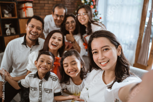 big family selfie on christmas day. asian people take picture using mobile phone © Odua Images