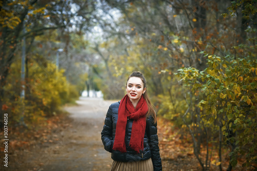 Portrait of a young beautiful woman in the autumn Park . The girl in the red scarf © fisher05