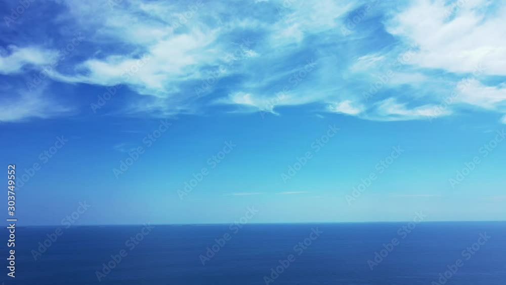 Peaceful heaven scenery with beautiful clouds hanging on light blue sky over endless deep blue Atlantic ocean, copy space Peaceful heaven scenery with beautiful clouds hanging on light blue sky over endless deep blue Atlantic ocean, copy space