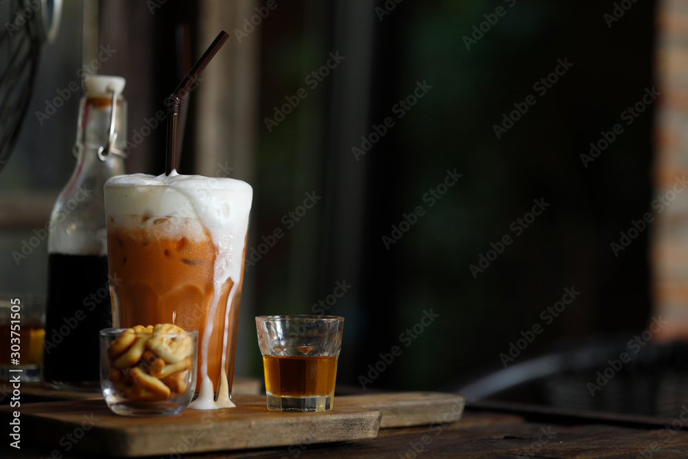 Iced milk tea with milk foam overflowing with aromatic syrup Iced milk tea with milk foam overflowing with aromatic syrup