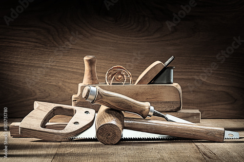 carpenter tools woodworkers plane wooden mallet chisel handsaw on vintage wooden background photo