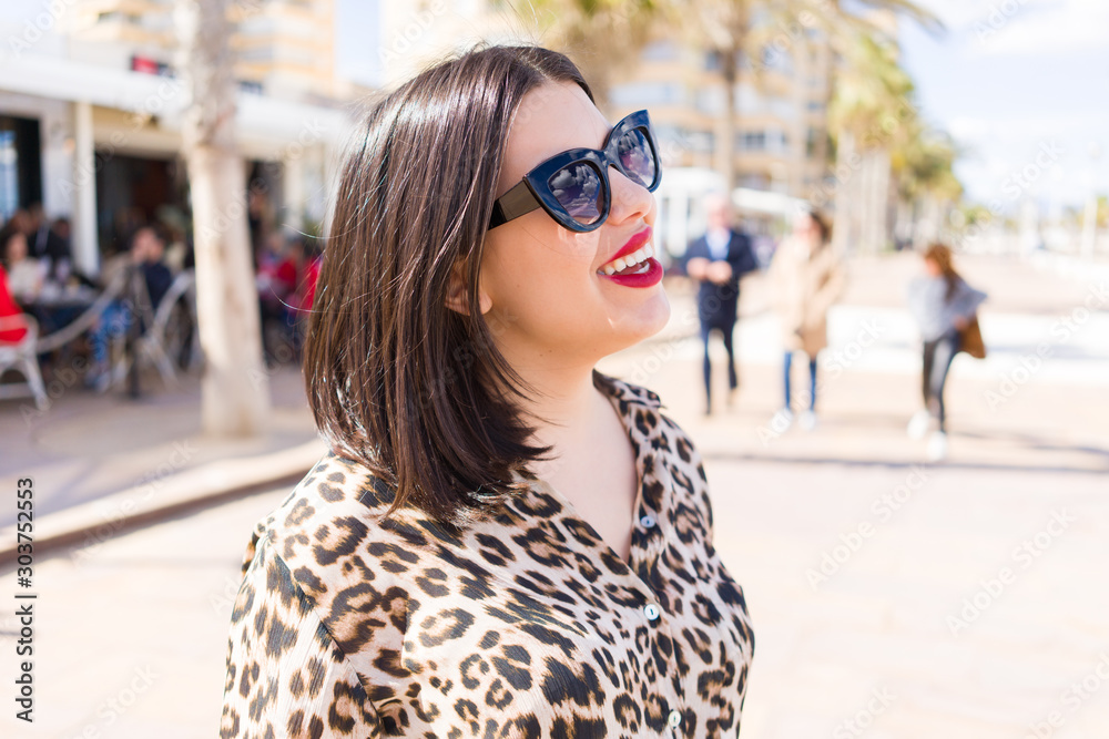 Young beautiful woman with red lips wearing sunglasses smiling happy at the street Young beautiful woman with red lips wearing sunglasses smiling happy at the street