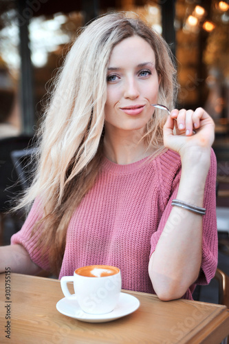 Beautiful woman with cup of latte outdoors.