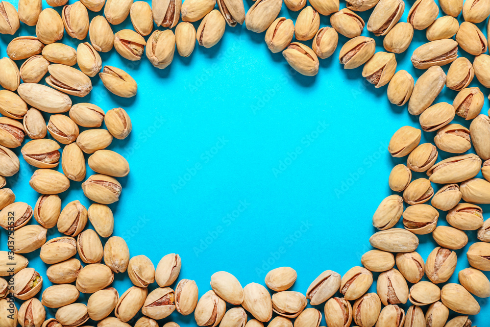 Frame made of tasty pistachio nuts on color background Frame made of tasty pistachio nuts on color background