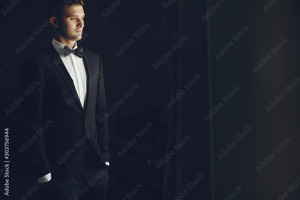 Elegant fiance standing near window. Businessman in a hotel room Elegant fiance standing near window. Businessman in a hotel room
