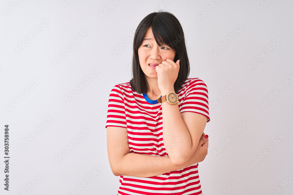 Young beautiful chinese woman wearing red striped t-shirt over isolated white background looking stressed and nervous with hands on mouth biting nails. Anxiety problem. Young beautiful chinese woman wearing red striped t-shirt over isolated white background looking stressed and nervous with hands on mouth biting nails. Anxiety problem.