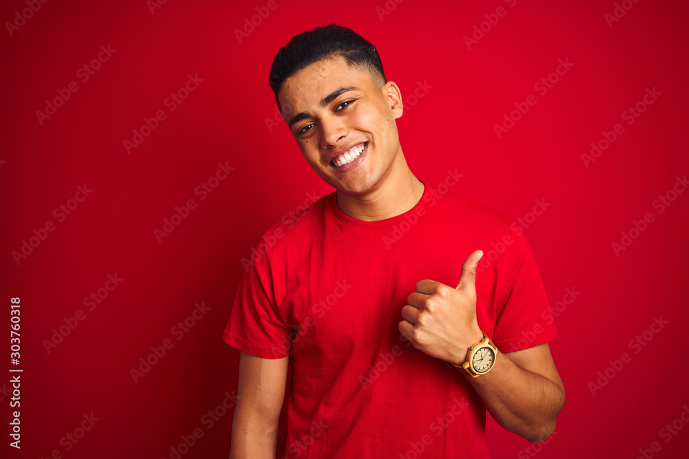 Φωτογραφία Young brazilian man wearing t-shirt standing over isolated red background doing happy thumbs up gesture with hand
