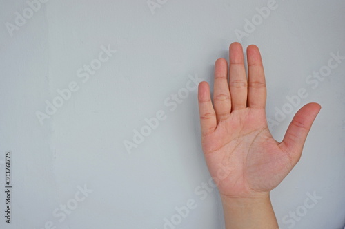 Close-up of female hand showing five fingers isolated on grey background. Side view close up details.