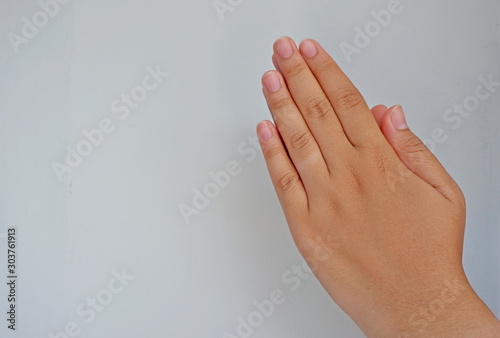 Hands of a caucasian female to shelter/pray or catch small object isolated on grey background. Side view close up details. © Hari