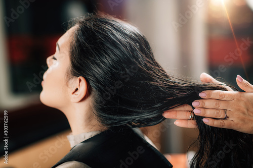 Hairstylist Applying Revitalizing Oil Drops on Woman’s Hair