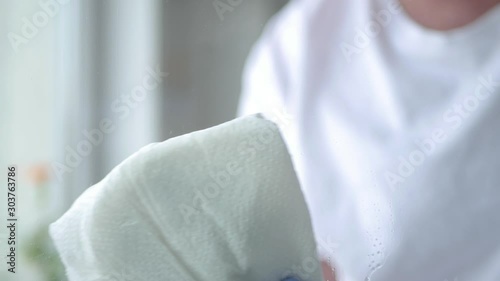 Close Up Man Hands with Blue Gloves Cleaning a Window