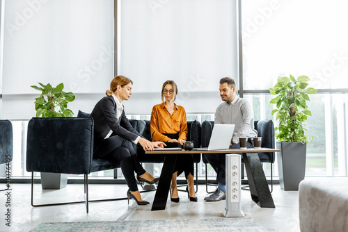 Young couple talking with financial consultant at the luxury bank office. Investment or lending concept for a young family photo