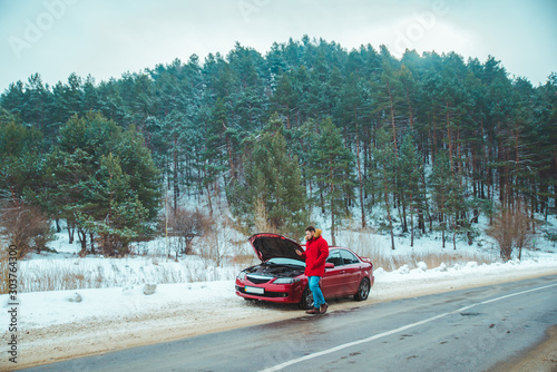 man standing near broken car at roadside snowed winter weather