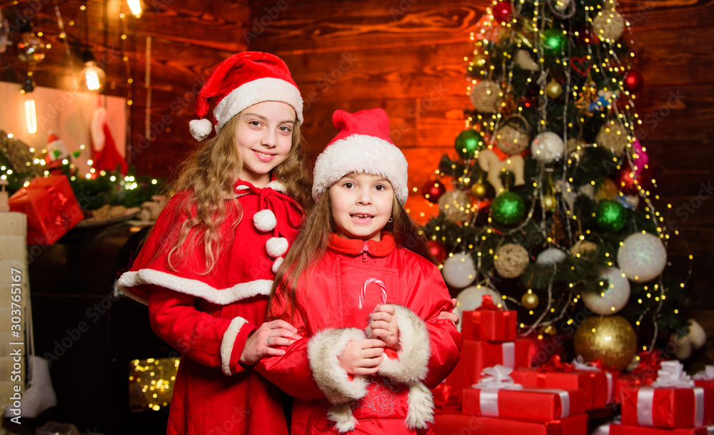 Christmas fun. Happy family celebrate new year. christmas time. Love winter holidays. small girl kids in red santa hat. wait for xmas gift. Winter shopping sales. Little sisters want present Christmas fun. Happy family celebrate new year. christmas time. Love winter holidays. small girl kids in red santa hat. wait for xmas gift. Winter shopping sales. Little sisters want present