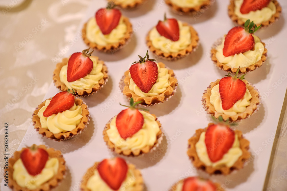 dessert with yellow cream and strawberries in a basket in a candy bar