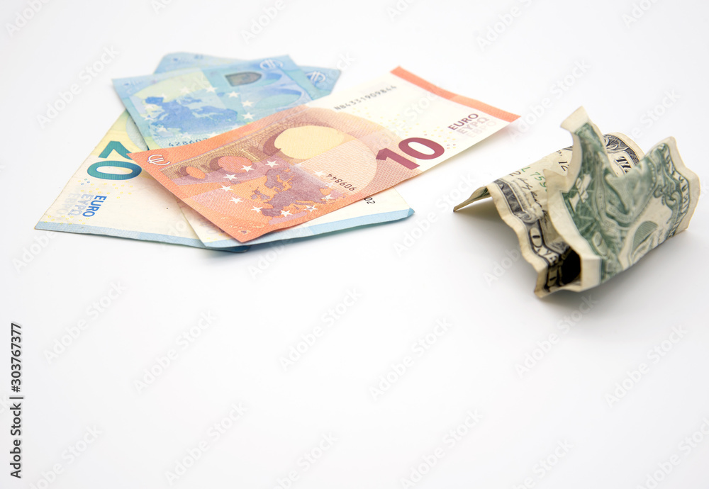 Several Euro bills and one crumpled dollar on a light background. Several Euro bills and one crumpled dollar on a light background.