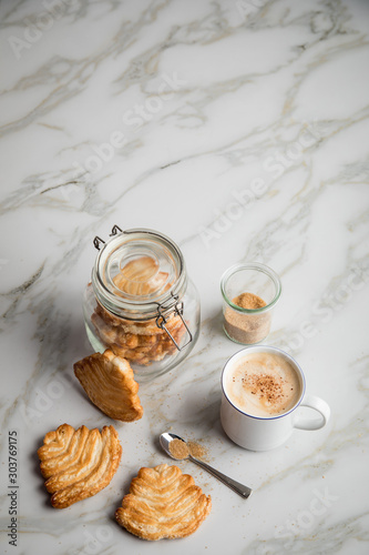 Italienische Blätterteig Fächer Kekse mit Einmachglas und Becher Kaffee auf Marmor Hintergrund