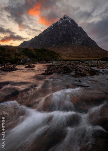 The Buachaille is a mountain in Glencoe, Scotland, the river in the for ground is the Coupall. Photo was taken during sunset with a slightly slower shutter speed. Glencoe is a area in the highlands.