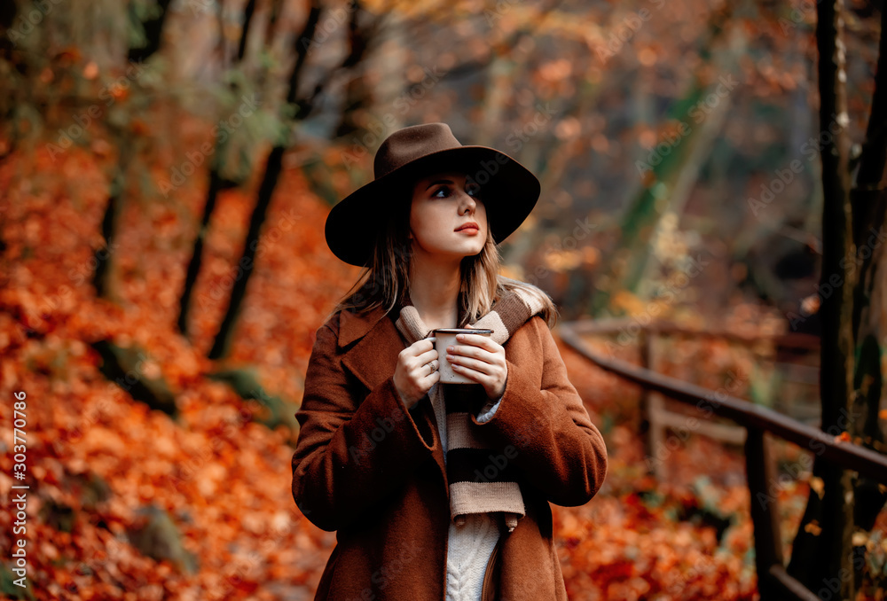 Φωτογραφία Young woman with cup of coffee in an autumn season park
