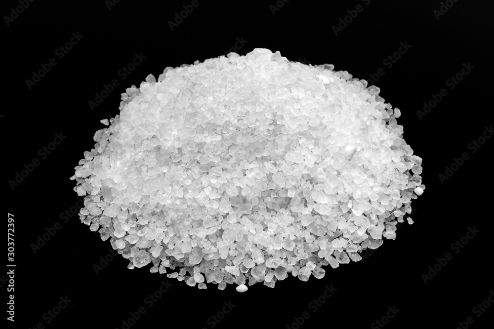White coarse rock salt on a black background