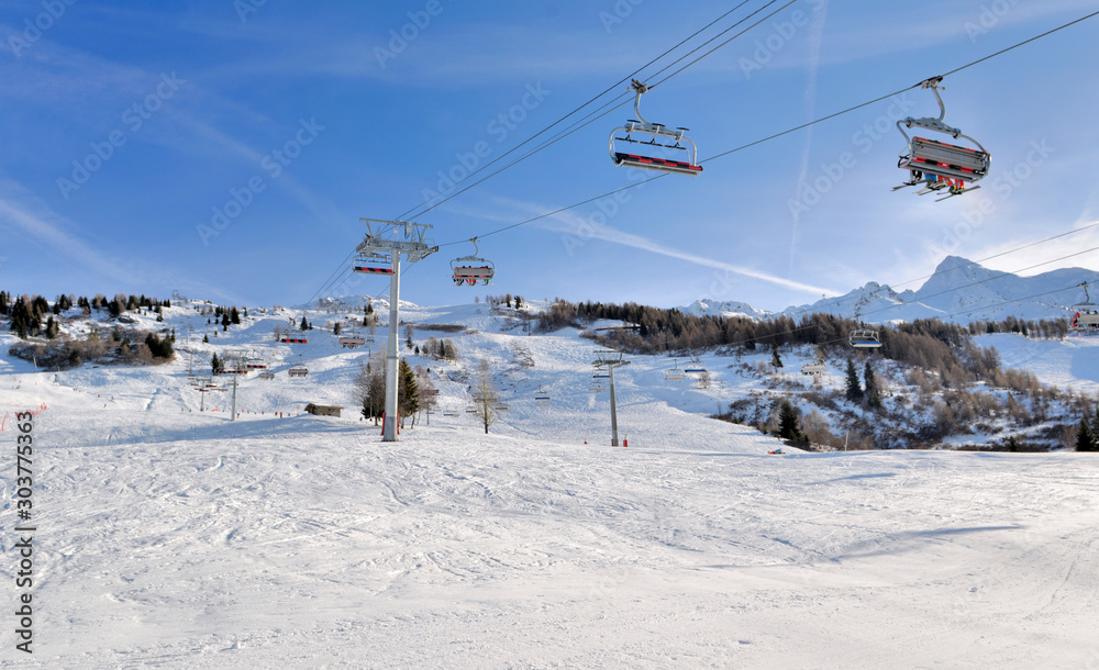 skiers on chairlifts in alpine resort at winter sports