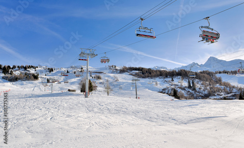 skiers on chairlifts in alpine resort at winter sports © coco