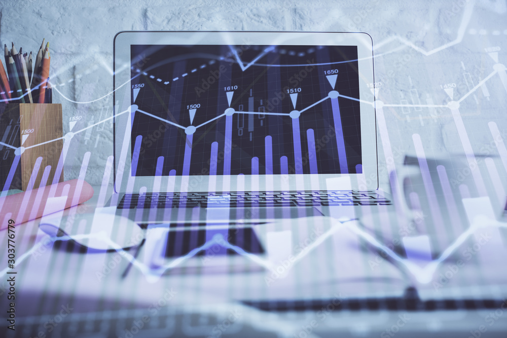 Stock market graph on background with desk and personal computer. Double exposure. Concept of financial analysis.