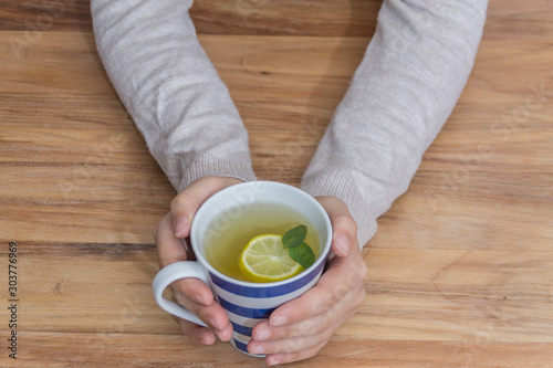 Hands holding a healthy hot tea for the flu