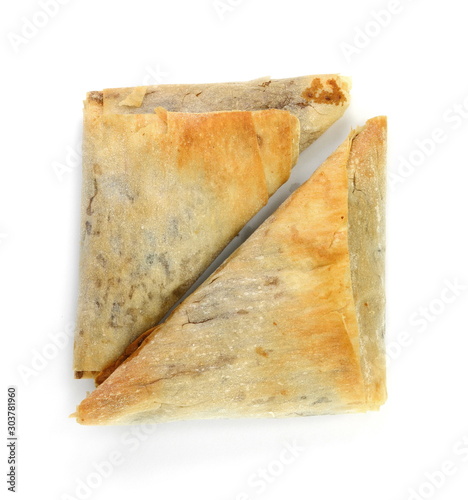 Sweet braided puff pastry or pate feuilletee isolated on white background with clipping path top view. Fresh phyllo pastry or triangular pie with apple jam inside close up photo