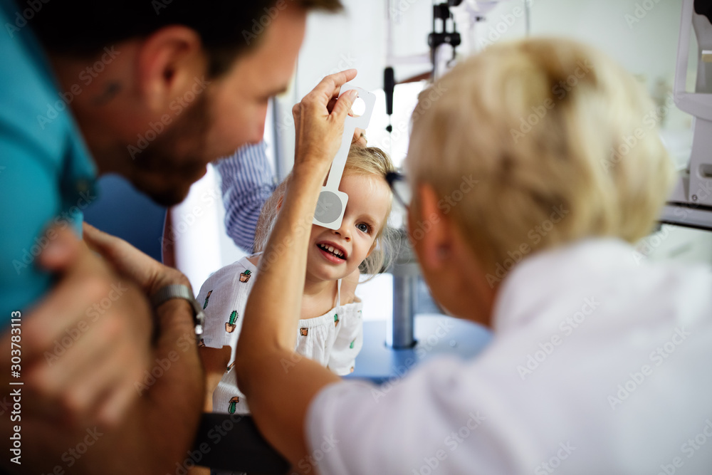 Φωτογραφία Ophthalmologist is checking the eye vision of little cute girl in modern clinic