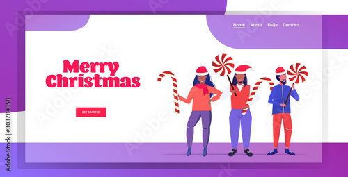 mix race people in santa claus hats holding sweetmeats candy cane and lollipop merry christmas happy new year winter holidays celebration concept horizontal copy space greeting card full length vector