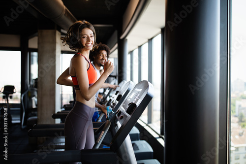 Fit group of people exercising on a treadmill in gym