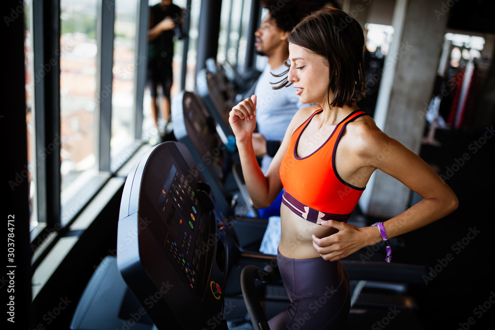 Fototapeta premium Healthy young athletes friends doing exercises at gym.