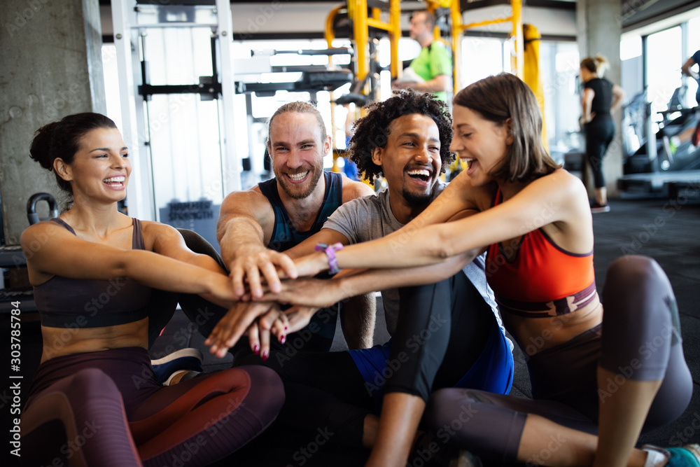 Happy fit friends exercising, working out in gym to stay healthy together Happy fit friends exercising, working out in gym to stay healthy together