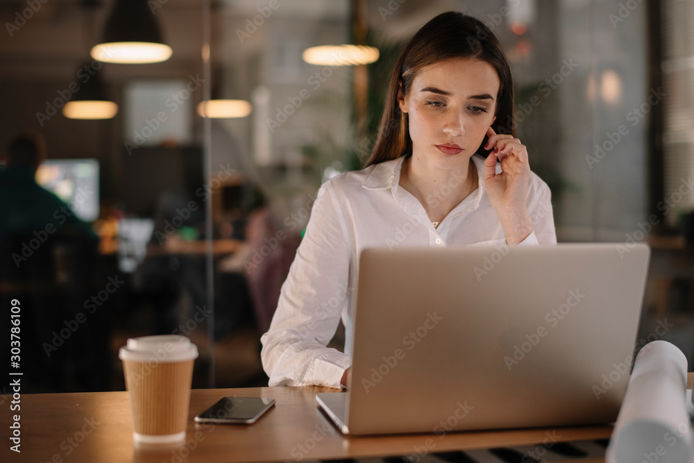 Young businesswoman in office. Beautiful female architect working late night. Young businesswoman in office. Beautiful female architect working late night.