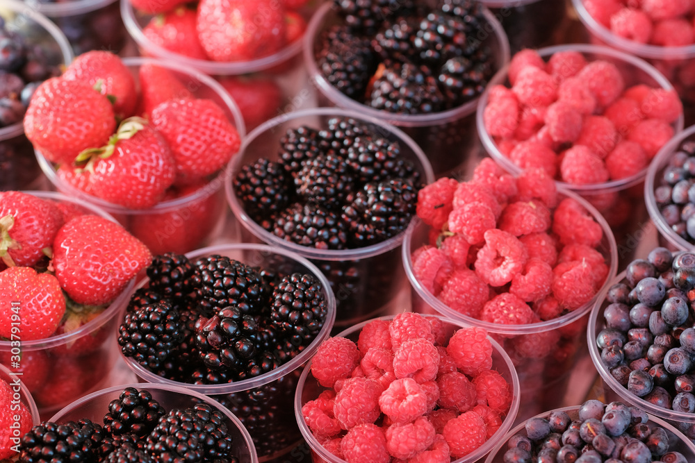 berries in plastic glasses. Fresh strawberries, raspberries, blackberries, blueberries in takeaway cups. market. berries in plastic glasses. Fresh strawberries, raspberries, blackberries, blueberries in takeaway cups. market.