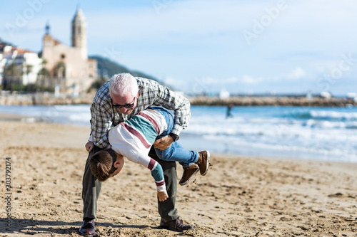 Grandfather playing with his grandson on Sitges, Spain.