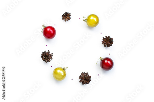 minimalistic christmas composition. Round festive frame on a white background with Christmas decorations, gold and red shiny ball,  cones, stars sparkles. top view, copy space, happy new year concept