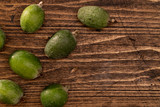 Feijoa fruits lying on textured wooden surface. Background, banner, frame